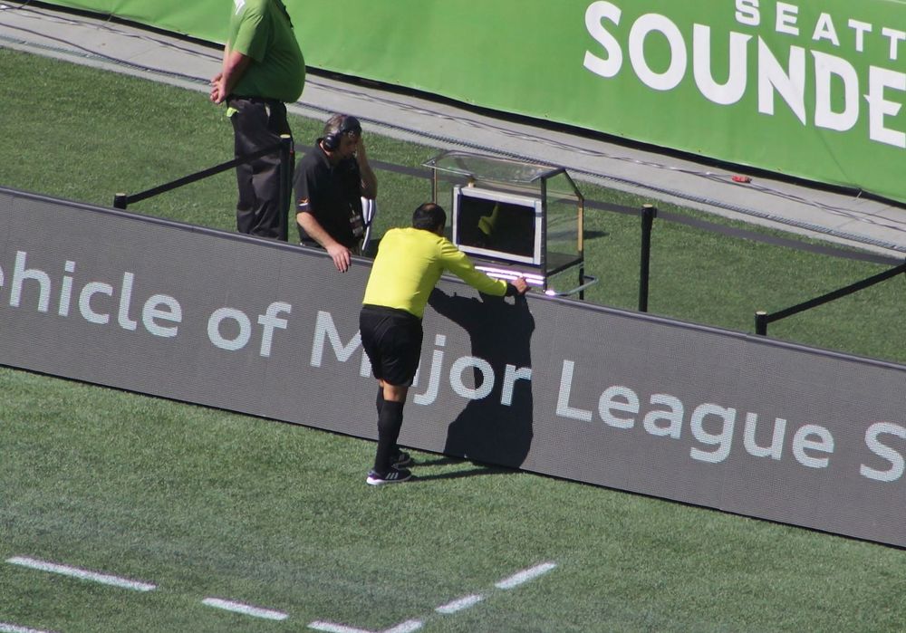 Árbitro consulta o monitor do VAR durante partida de futebol nos Estados Unidos